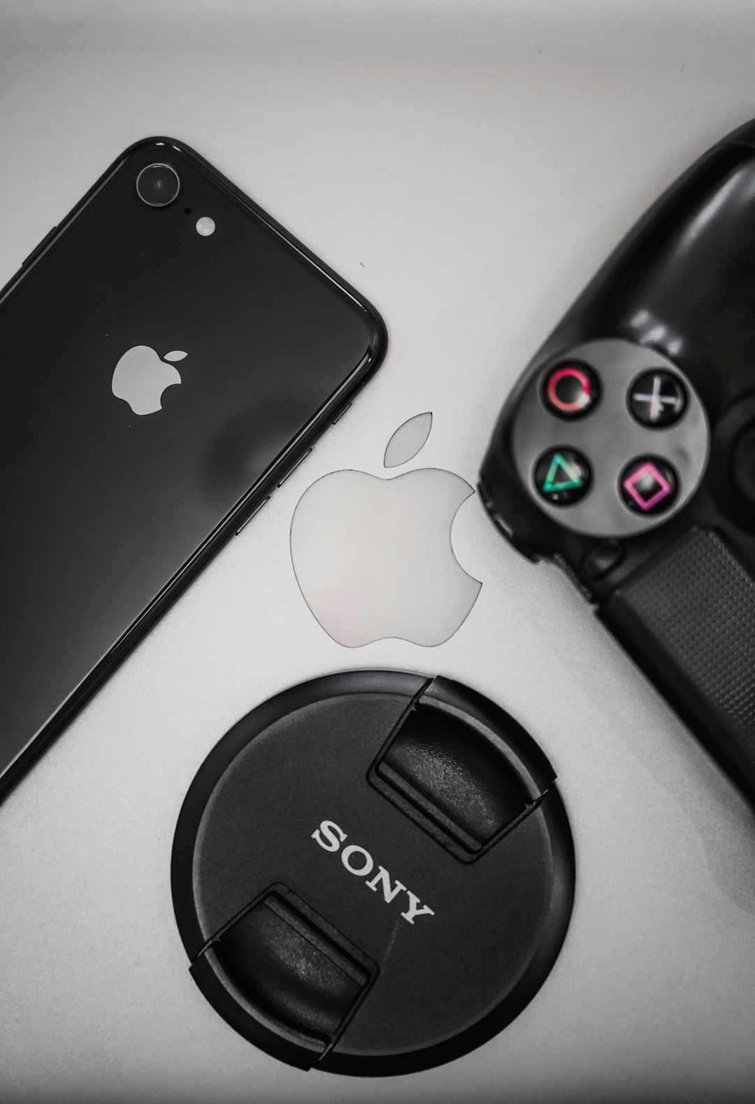 black iphone 7 beside black logitech camera lens cover