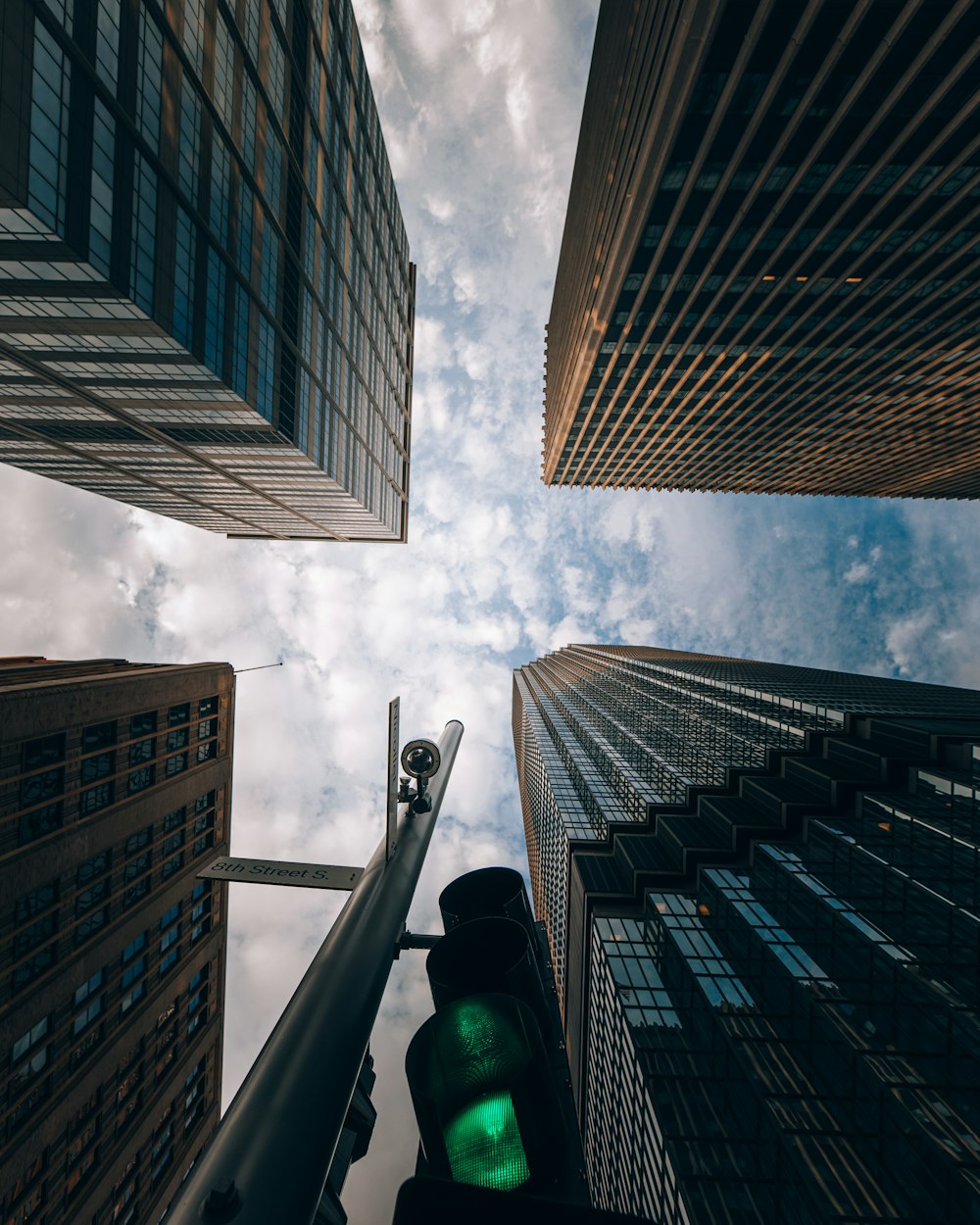 low angle photography of high rise buildings under white clouds during daytime