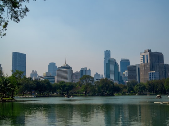 city skyline across body of water during daytime in Lumphini Park Thailand