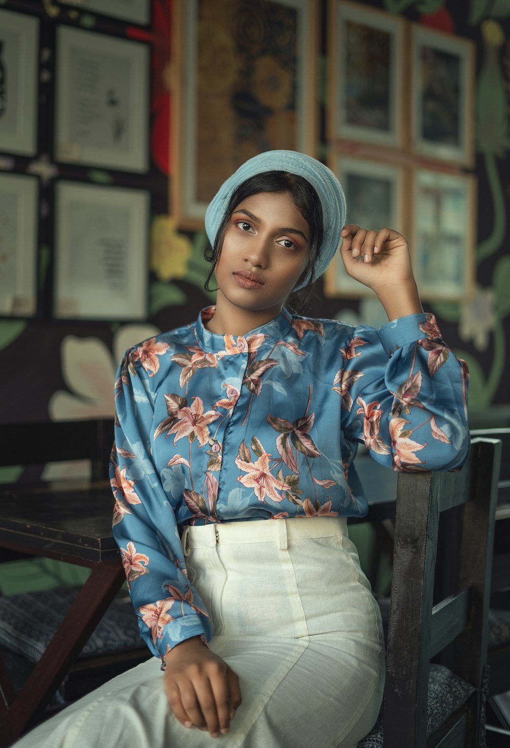 donna in camicia a maniche lunghe floreali blu e rosse e berretto in maglia blu