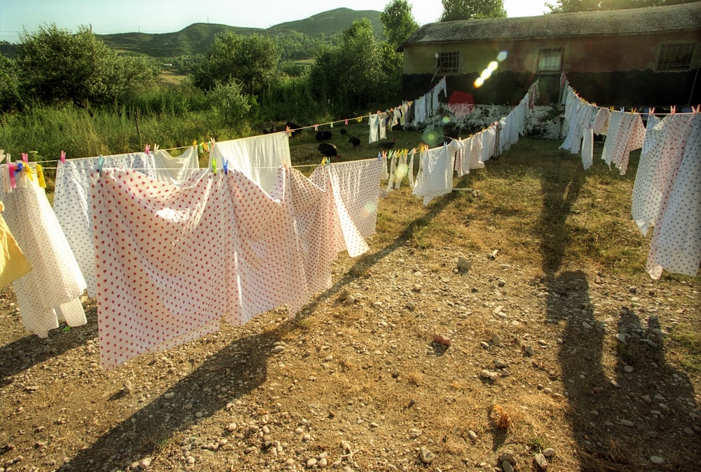 Textil blanco y rojo colgado en una cerca de alambre durante el día