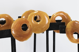 Five polished amber pieces arranged near the logo on white background.