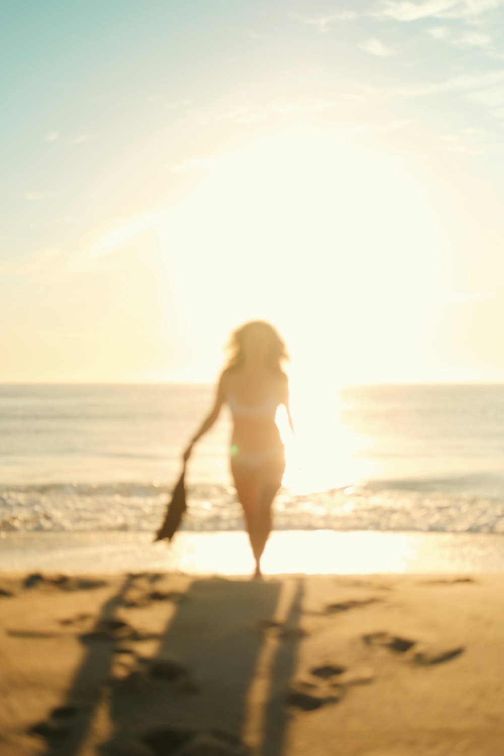 woman in white bikini walking on beach during daytime