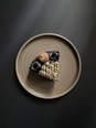 brown and black dog figurine on white ceramic round plate