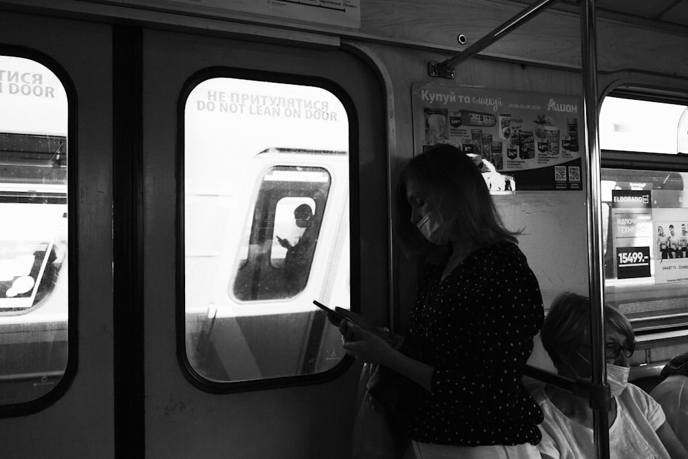 woman in polka dot shirt standing in train