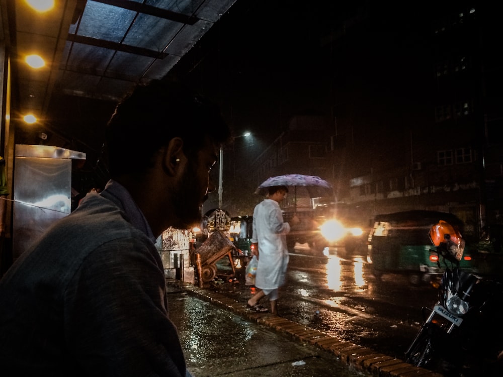 man in blue jacket holding umbrella during night time