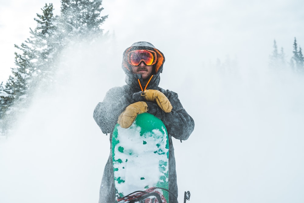 Hombre con chaqueta marrón con gafas de nieve negras y verdes