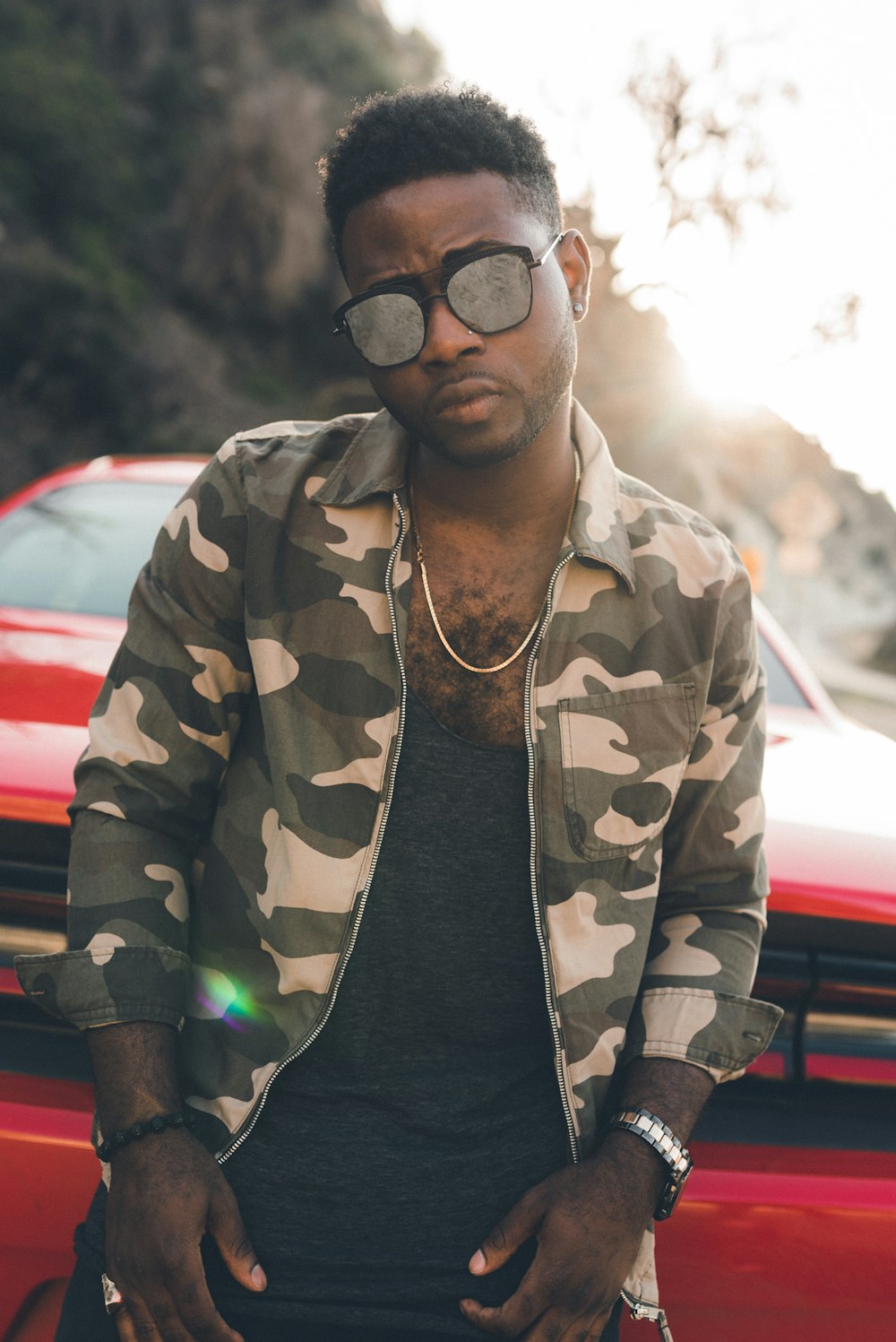 man in green and beige camouflage jacket wearing black framed eyeglasses