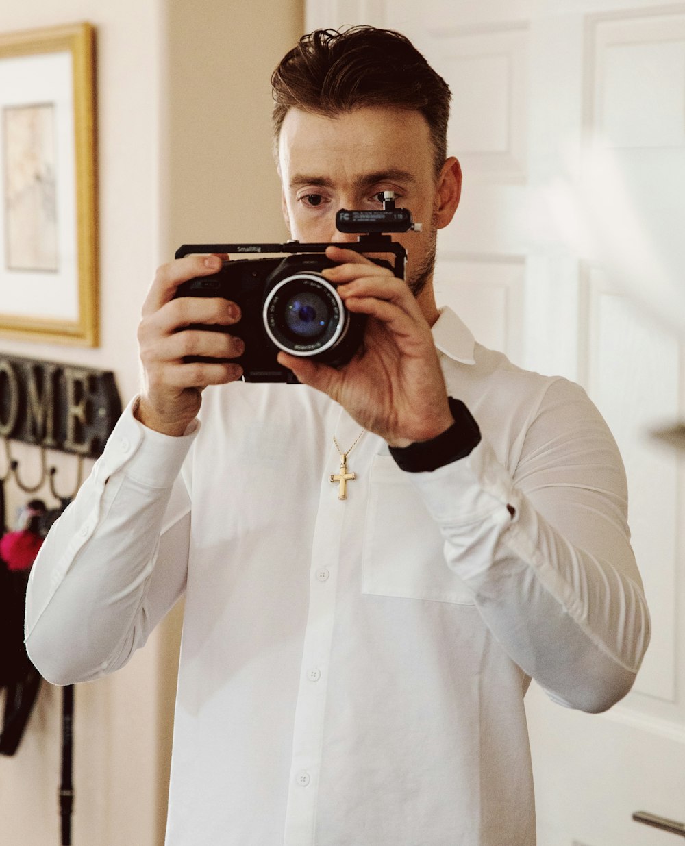 man in white dress shirt holding black camera