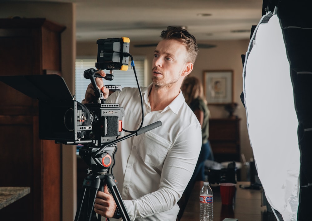 man in gray long sleeve shirt holding black video camera