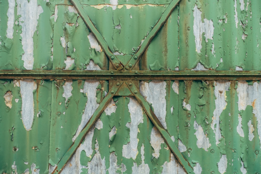 green wooden door with gray metal door handle
