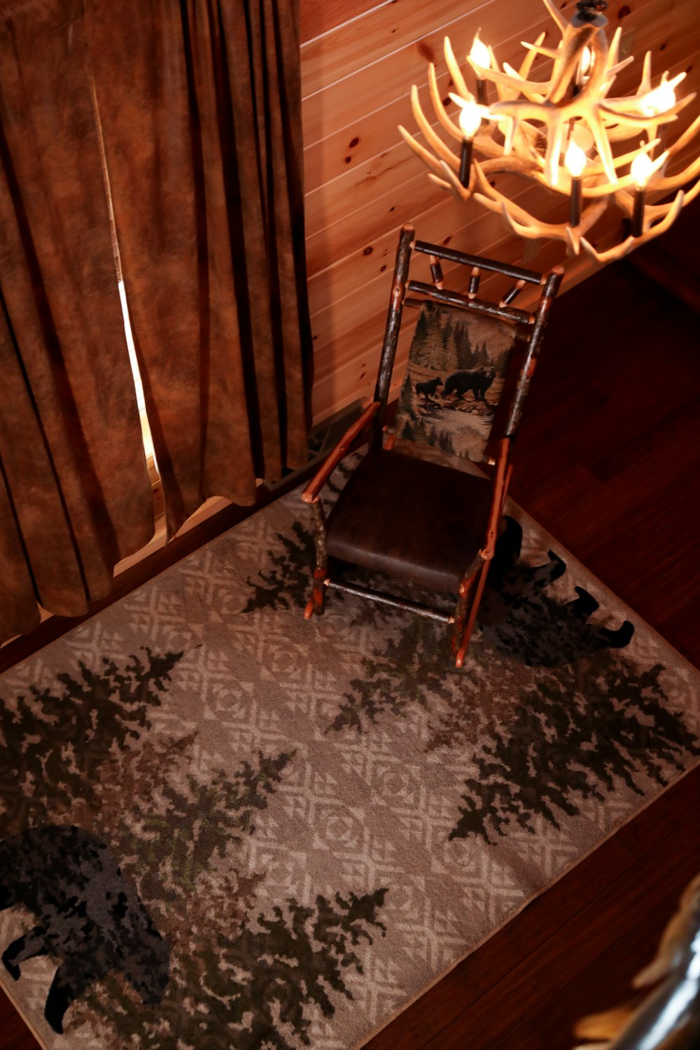 brown wooden chair on brown and white floral area rug