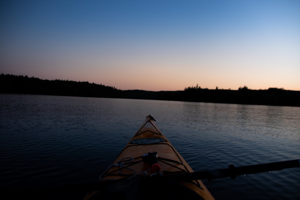 person riding on boat on lake during sunset