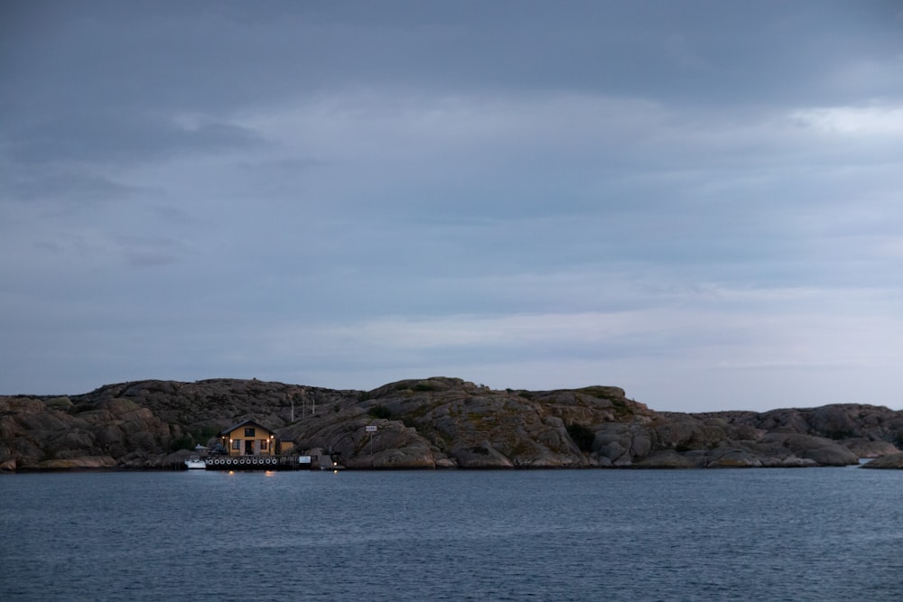 brown and white house on island under white clouds during daytime