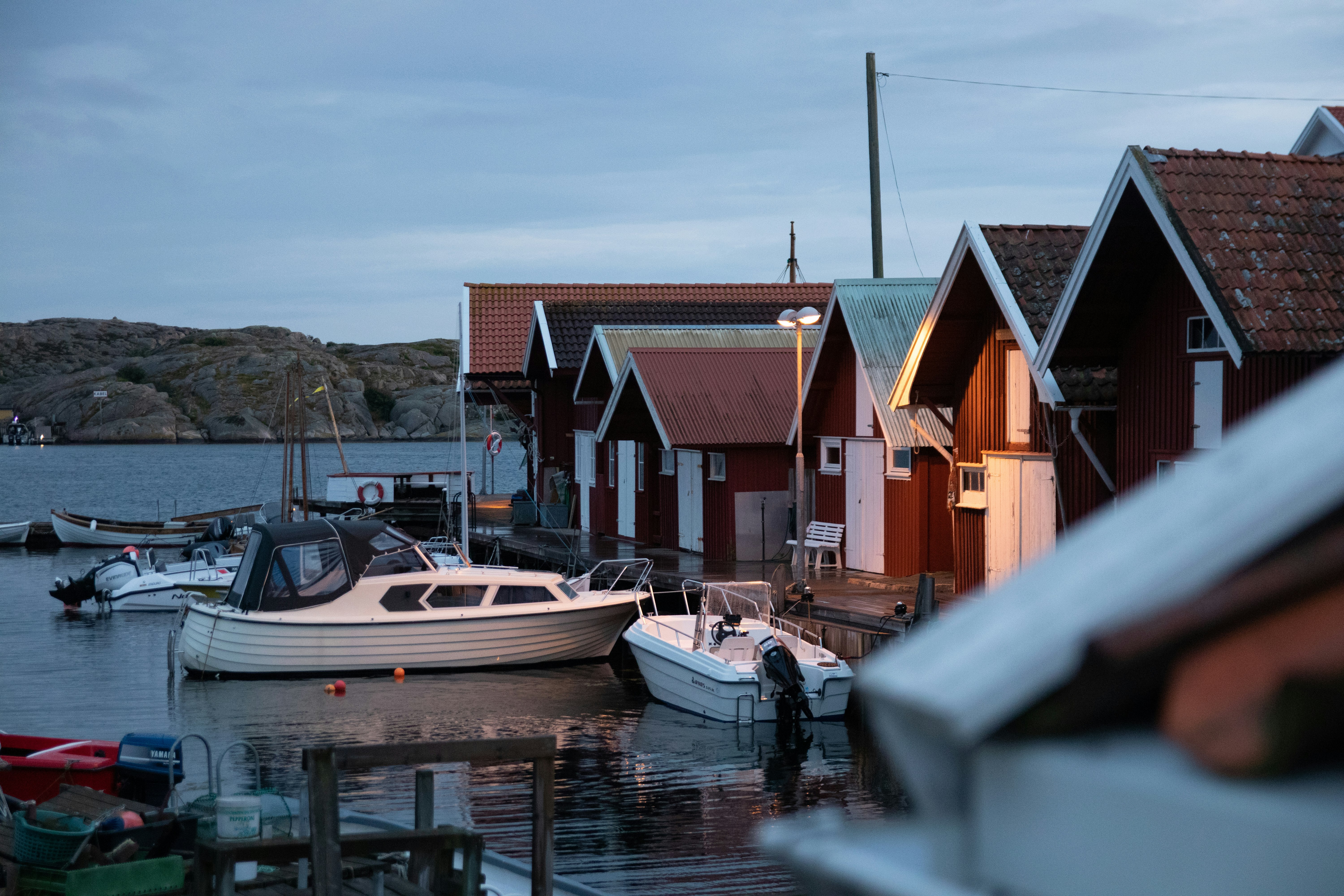 white and brown boat on dock near houses during daytime