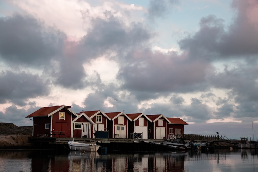 white and brown house beside body of water under cloudy sky during daytime