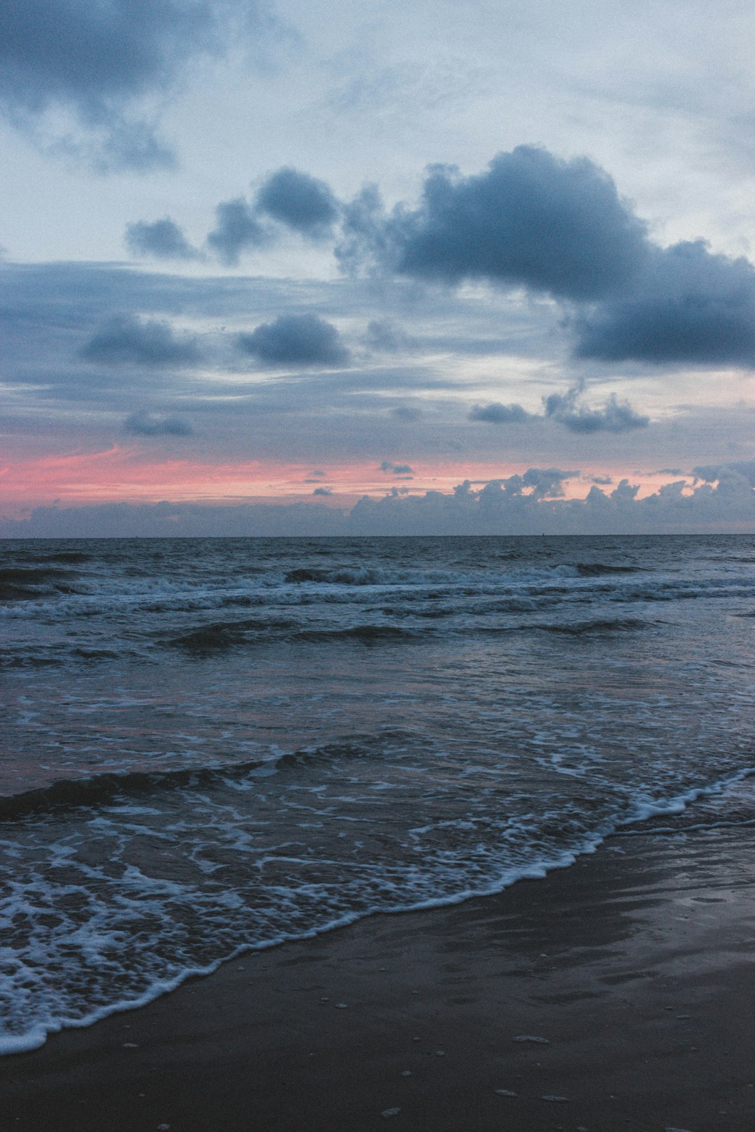 ocean waves crashing on shore during sunset