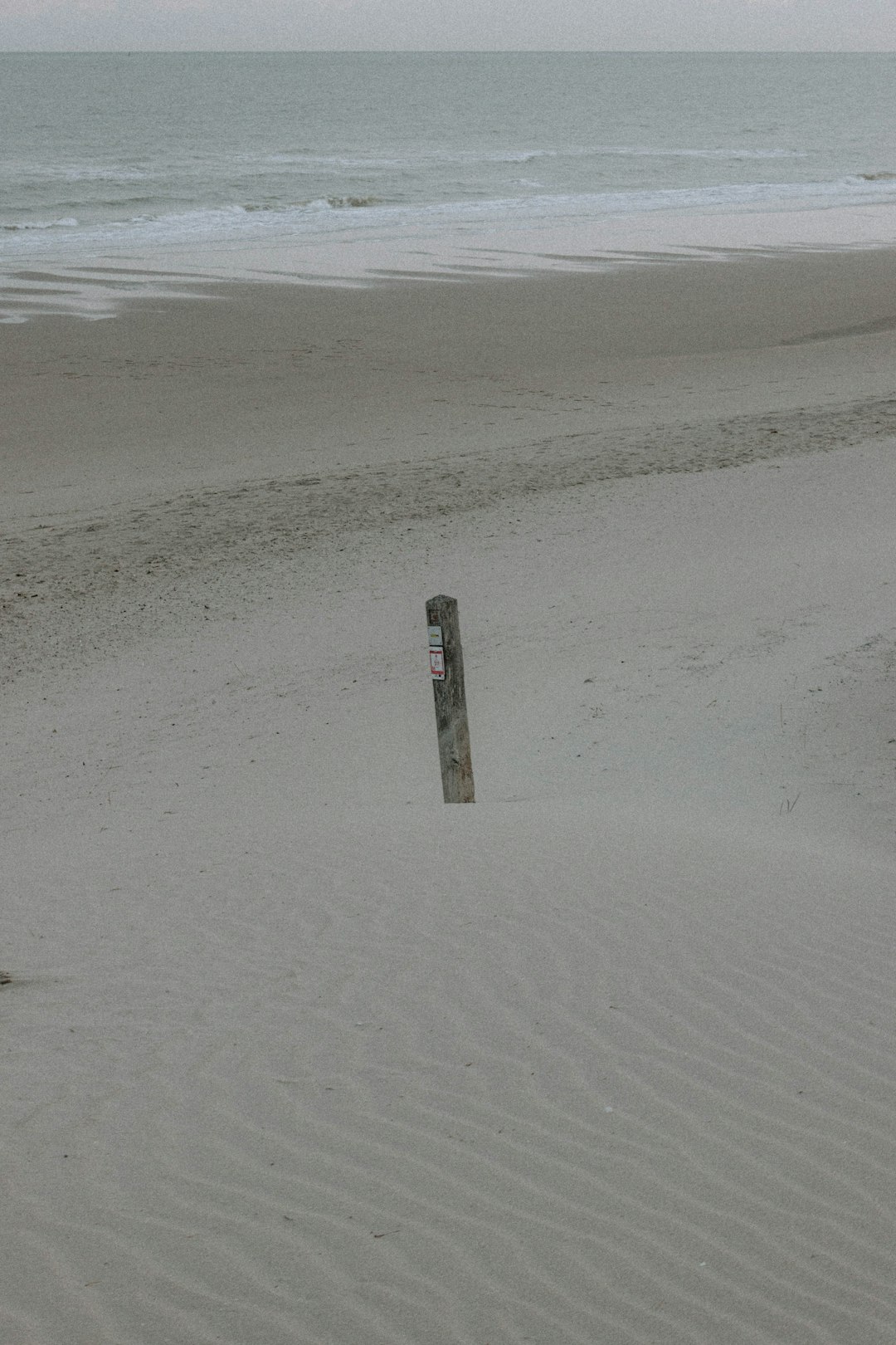 brown wooden post on brown sand