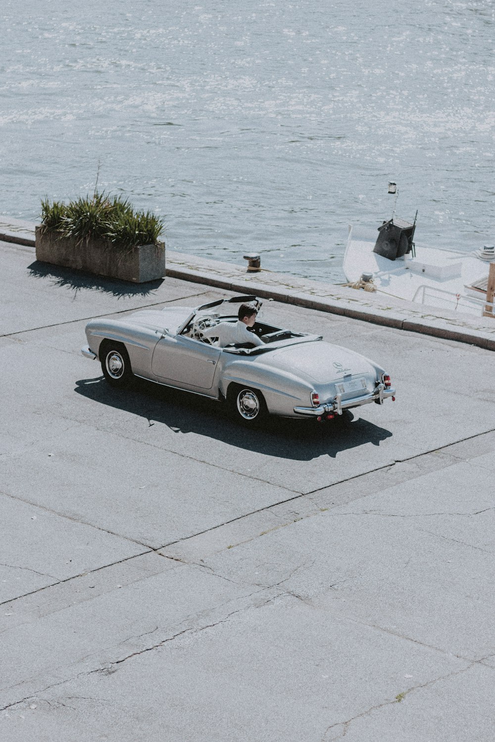 black convertible coupe on gray concrete road during daytime