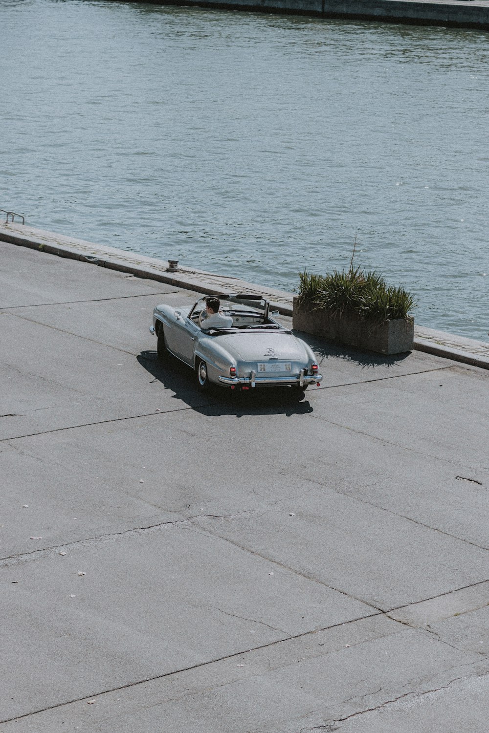 white coupe parked beside sea during daytime