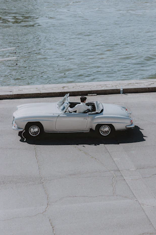 A sleek convertible cruising along a coastal highway with ocean views.