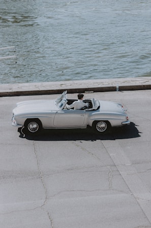 A stylish convertible cruising along a scenic road.
