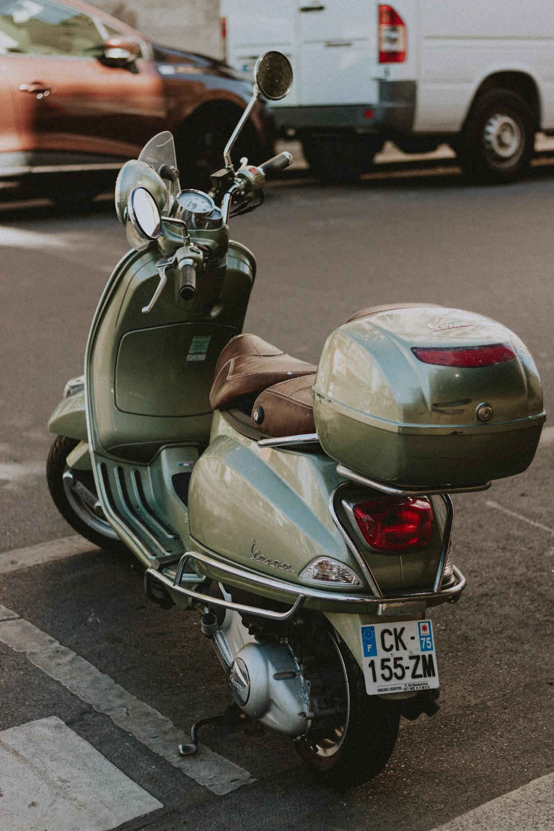 gray motor scooter parked on gray concrete road during daytime