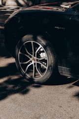 Close-up of a tire with deep black shine and detailed tread, glistening under natural light