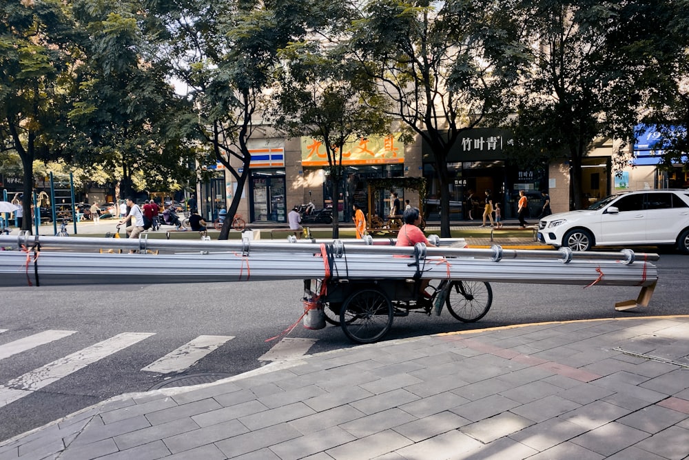 people sitting on bench near road during daytime