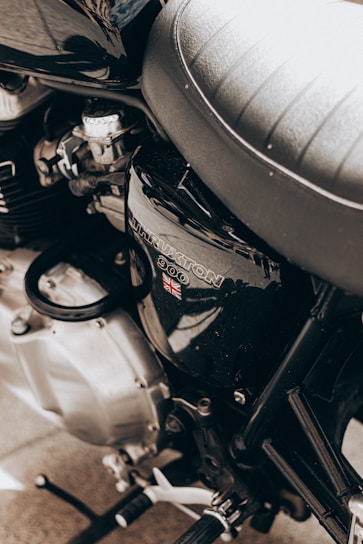 Close-up of a custom-fitted royal enfield bike seat cover in rugged black leather stitching.
