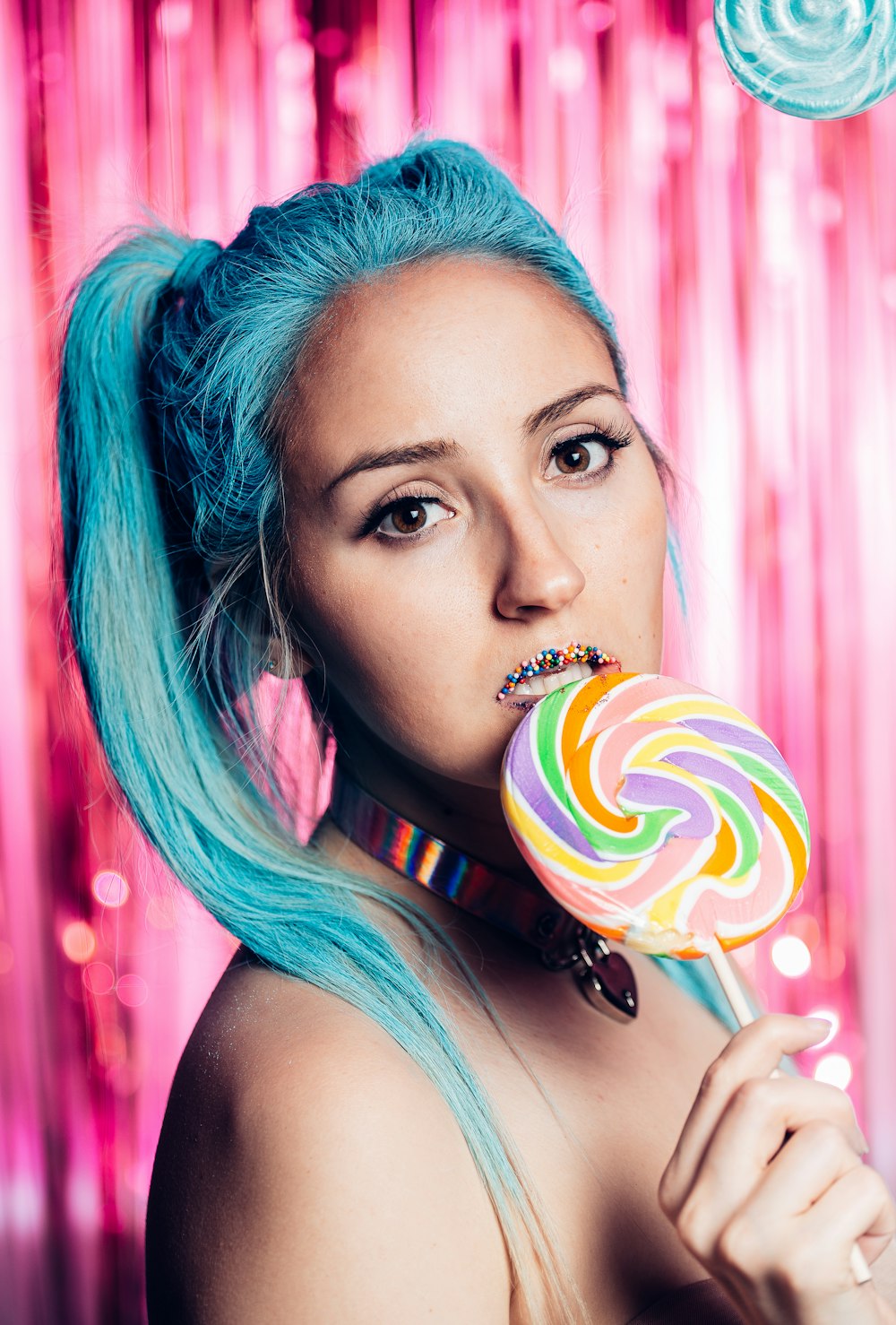 woman with purple hair holding lollipop