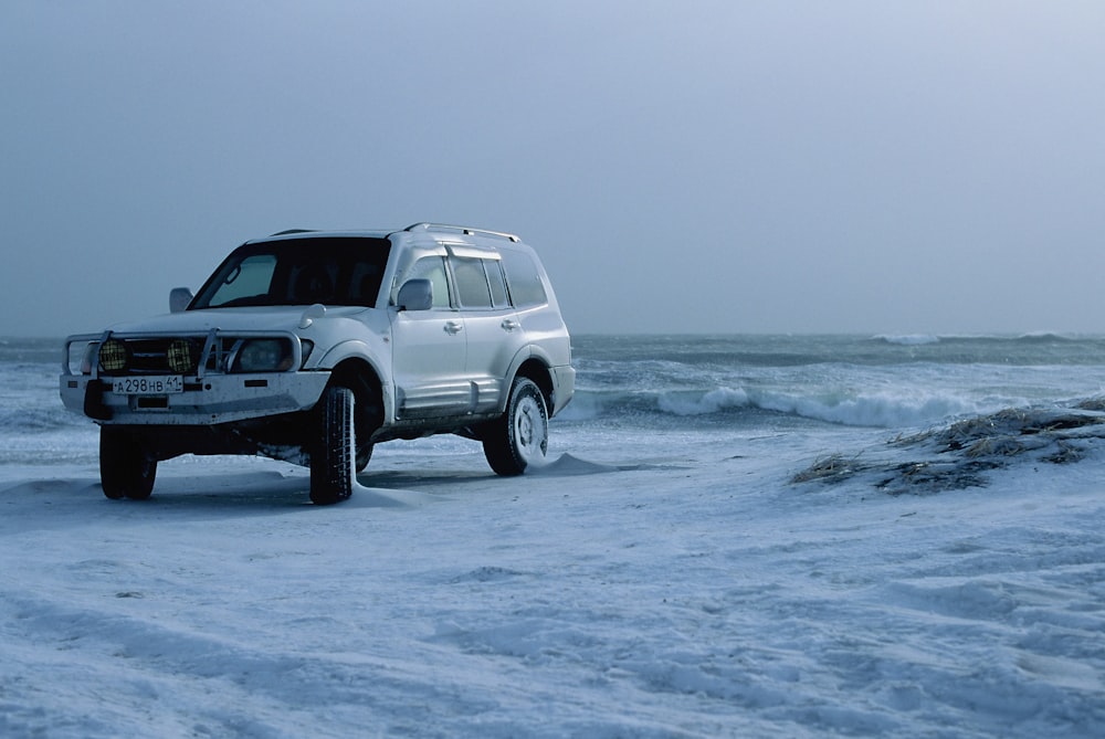 white suv on sea shore during daytime