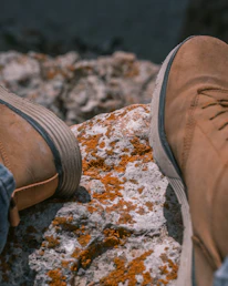 Close-up of high-performance hunting boots resting on mossy ground.