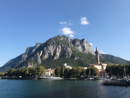 white boat on water near mountain during daytime in Lecco Italy