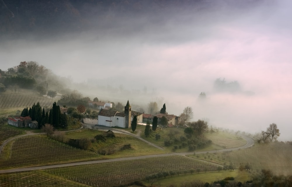 Weißes und braunes Haus auf grünem Rasenfeld unter weißem Himmel tagsüber