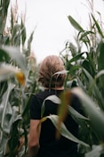 woman in black shirt standing on green grass field during daytime