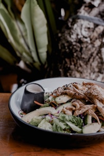 A vibrant bowl of fresh, colorful salad with grilled chicken and seasonal vegetables.