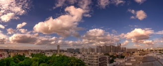 A panoramic cityscape featuring sleek condo towers and bustling office buildings under a clear sky.