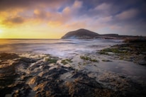 ocean waves crashing on shore during sunset