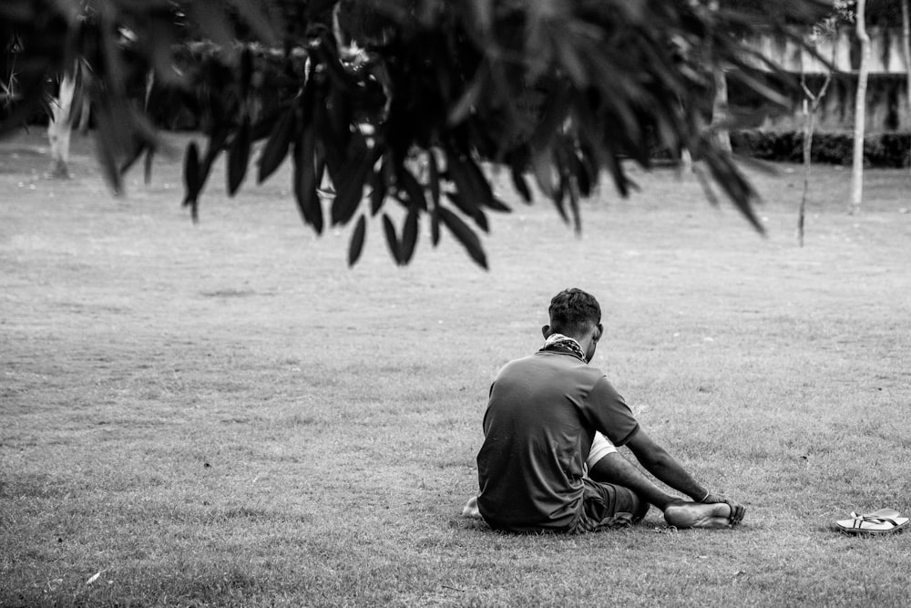 man in gray t-shirt sitting on ground