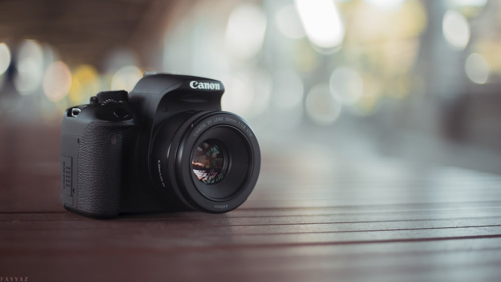 black nikon dslr camera on brown wooden table