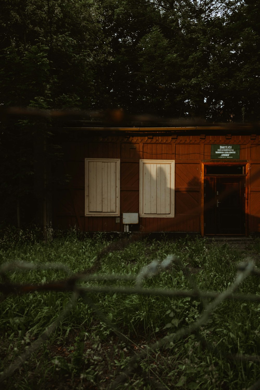 Casa de madera marrón con campo de césped verde