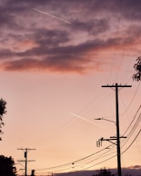 black electric post under orange sky