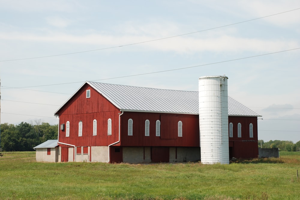 red and white wooden house on green grass field during daytime