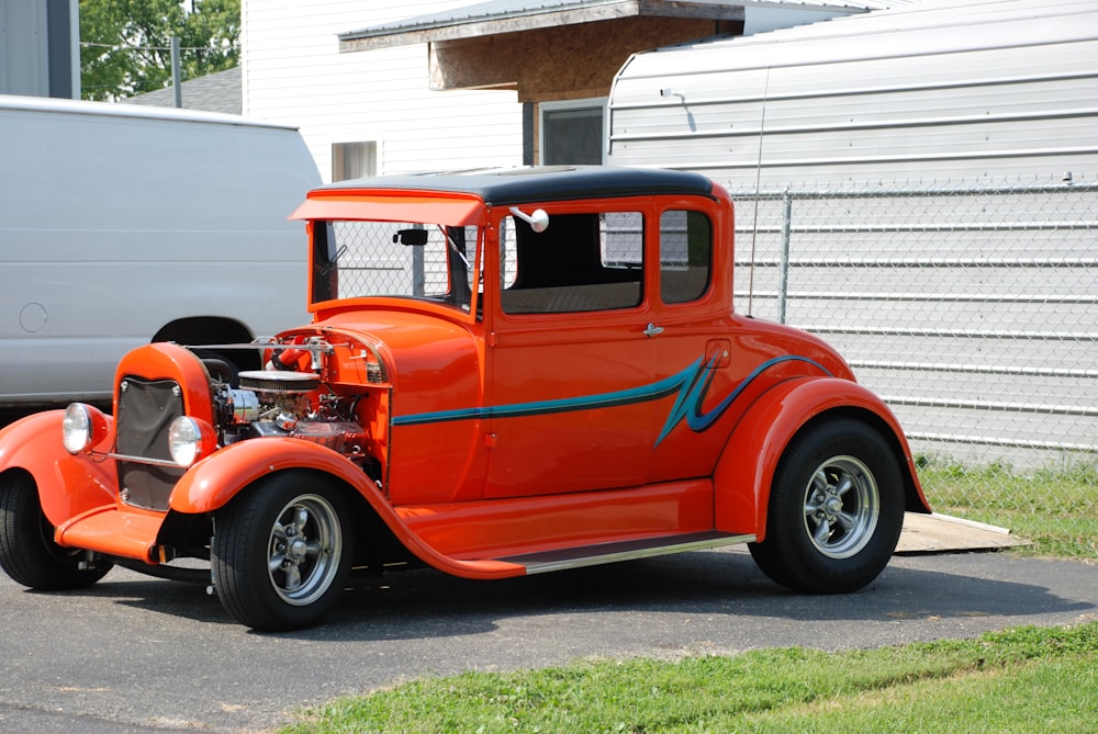 red vintage car parked beside white building