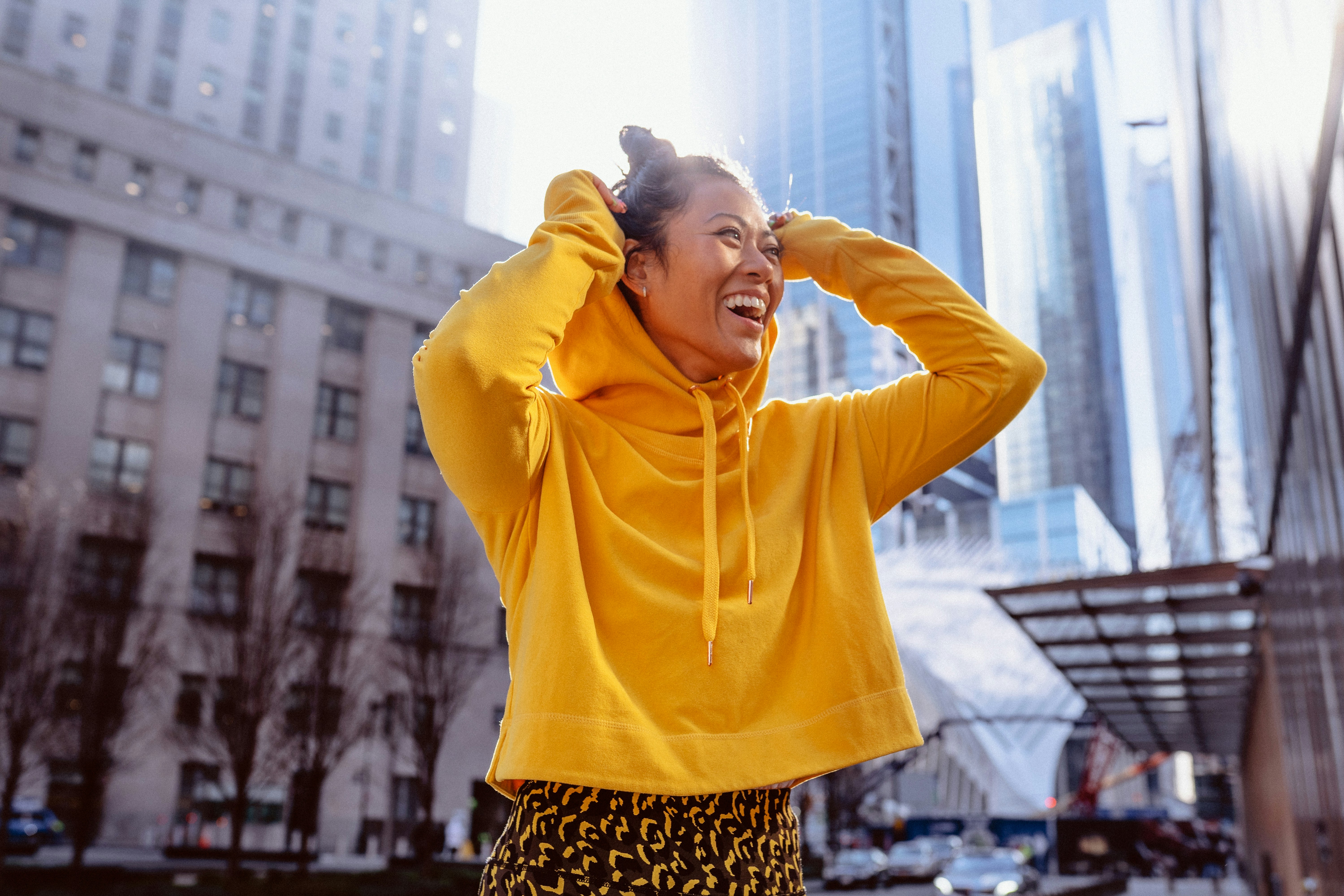 woman in yellow long sleeve shirt standing on building during daytime