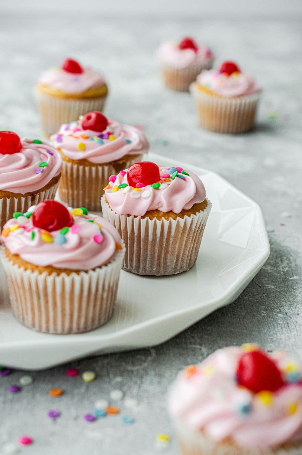 Cupcakes con glaseado blanco en plato de cerámica blanca