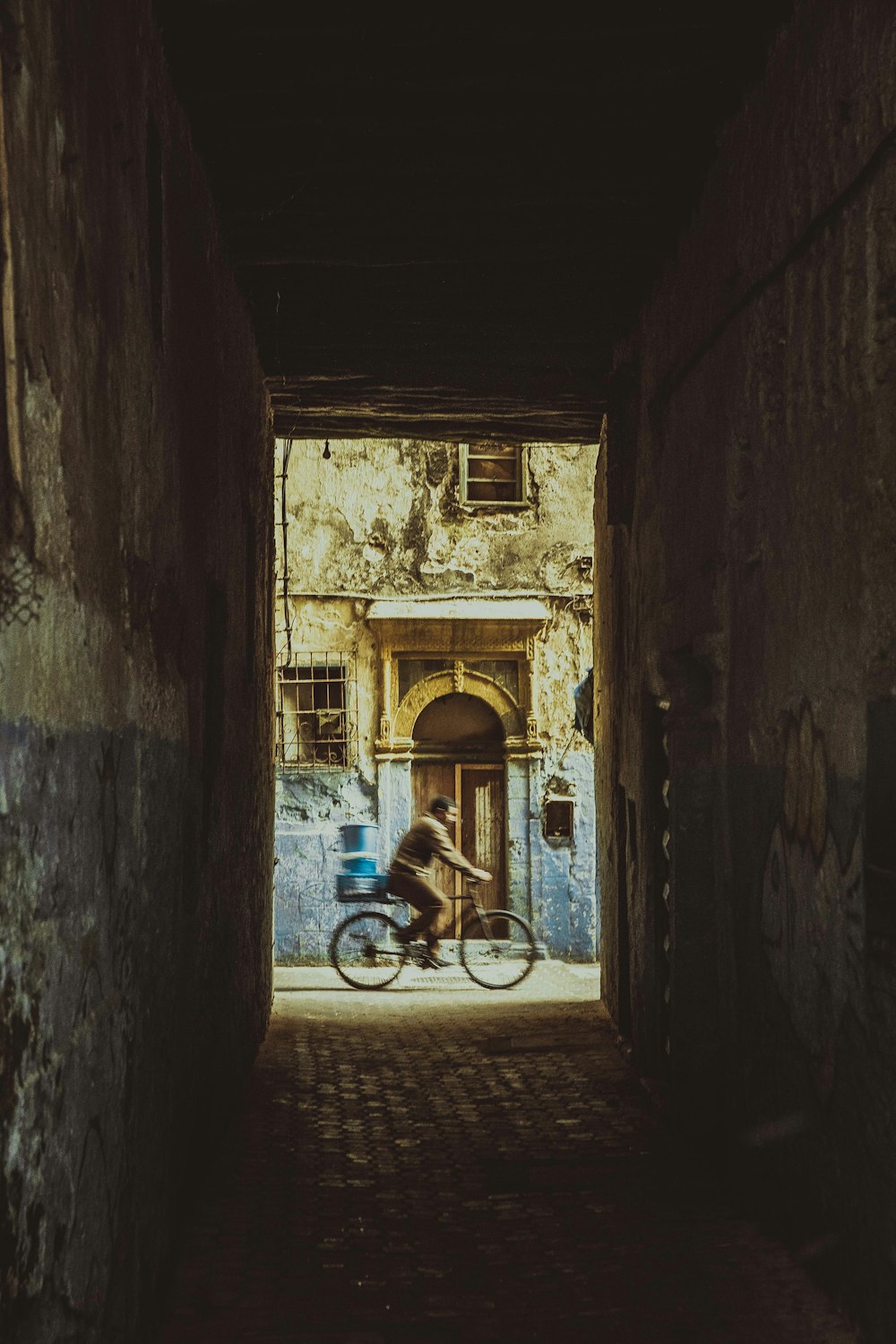 man in blue shirt riding bicycle in tunnel during daytime