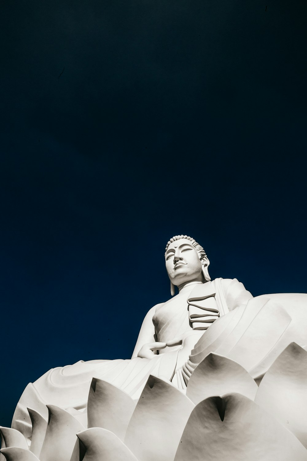 Estatua de hormigón blanco bajo el cielo azul durante el día