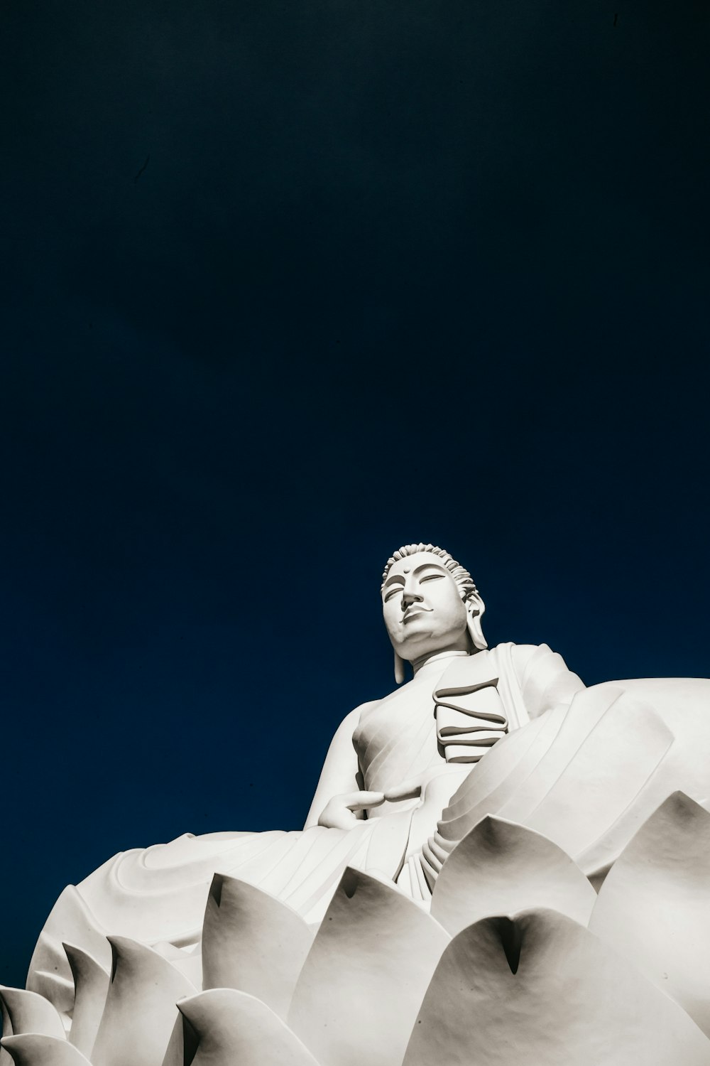 Statua di cemento bianco sotto cielo blu durante il giorno